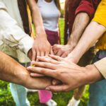 Group,Of,People,Stacking,Hands,Together,-,Team,Building,Celebrating
